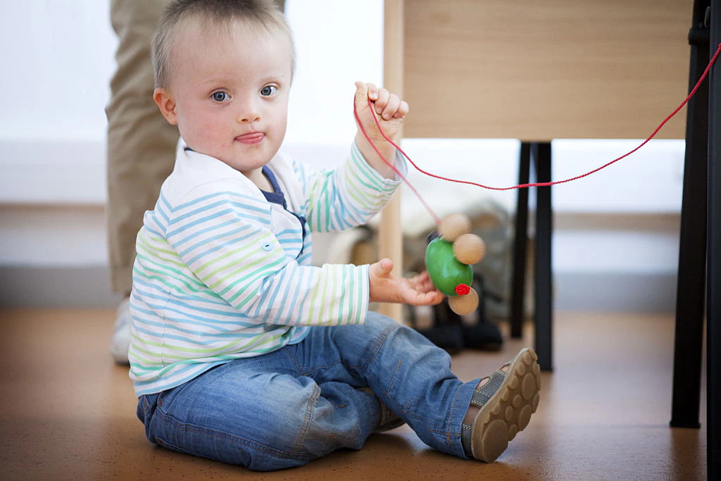 Reportage at the Jerome Lejeune Institute in Paris, France. The Institute treats patients suffering from Down's Syndrome and other intellectual disabilities of genetic origin. A multidisciplinary team deals with all care for these patients, offering specialised Down's Syndrome consultations. This little Down's boy is spending a day undergoing tests at the Institute for a research programme. He is seen here with a neuropsychologist. (Photo by: BSIP/Universal Images Group via Getty Images)