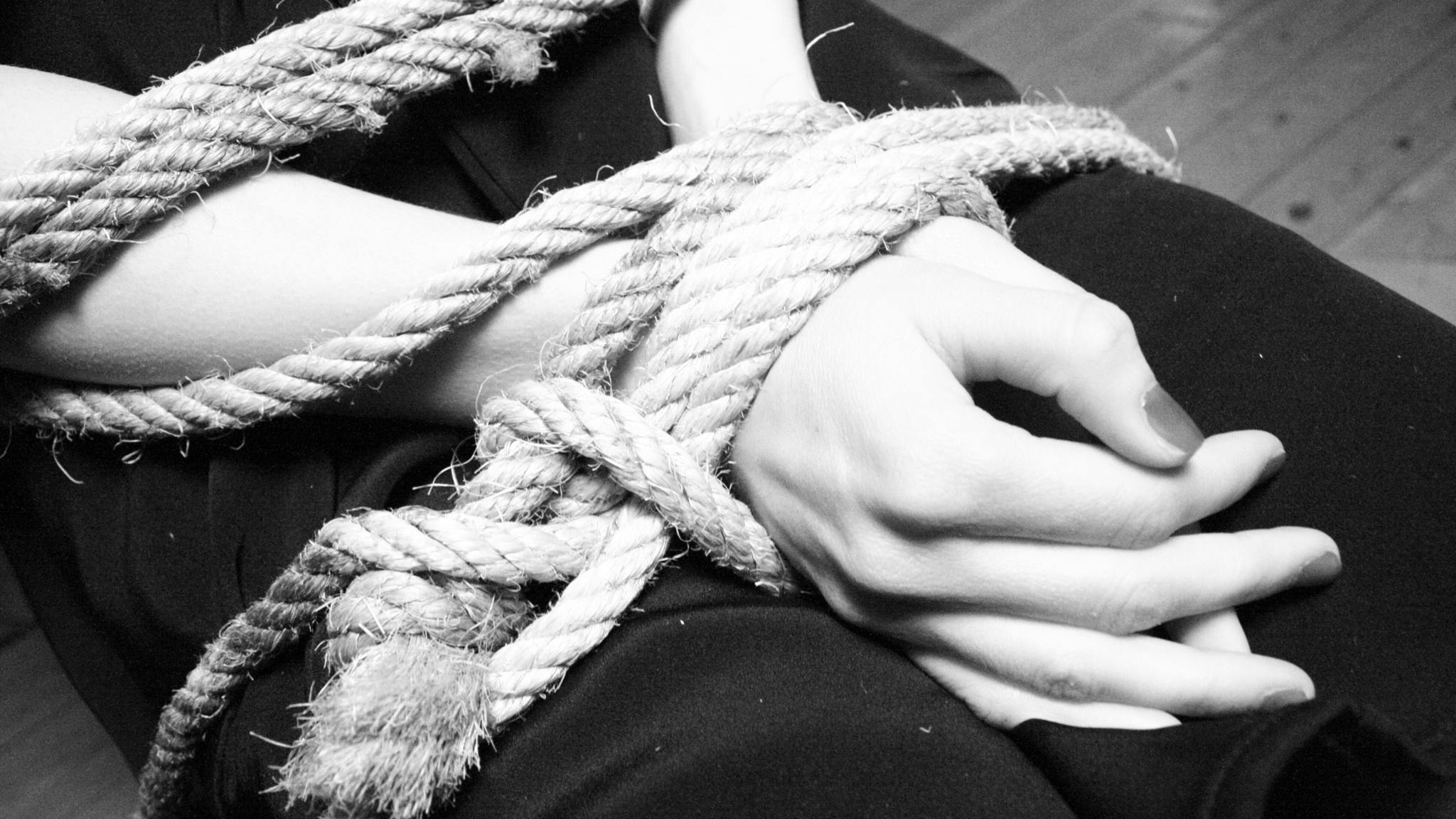 Midsection Of Woman Tied Up With Rope Midsection Of Woman Tied Up With Rope - stock photo