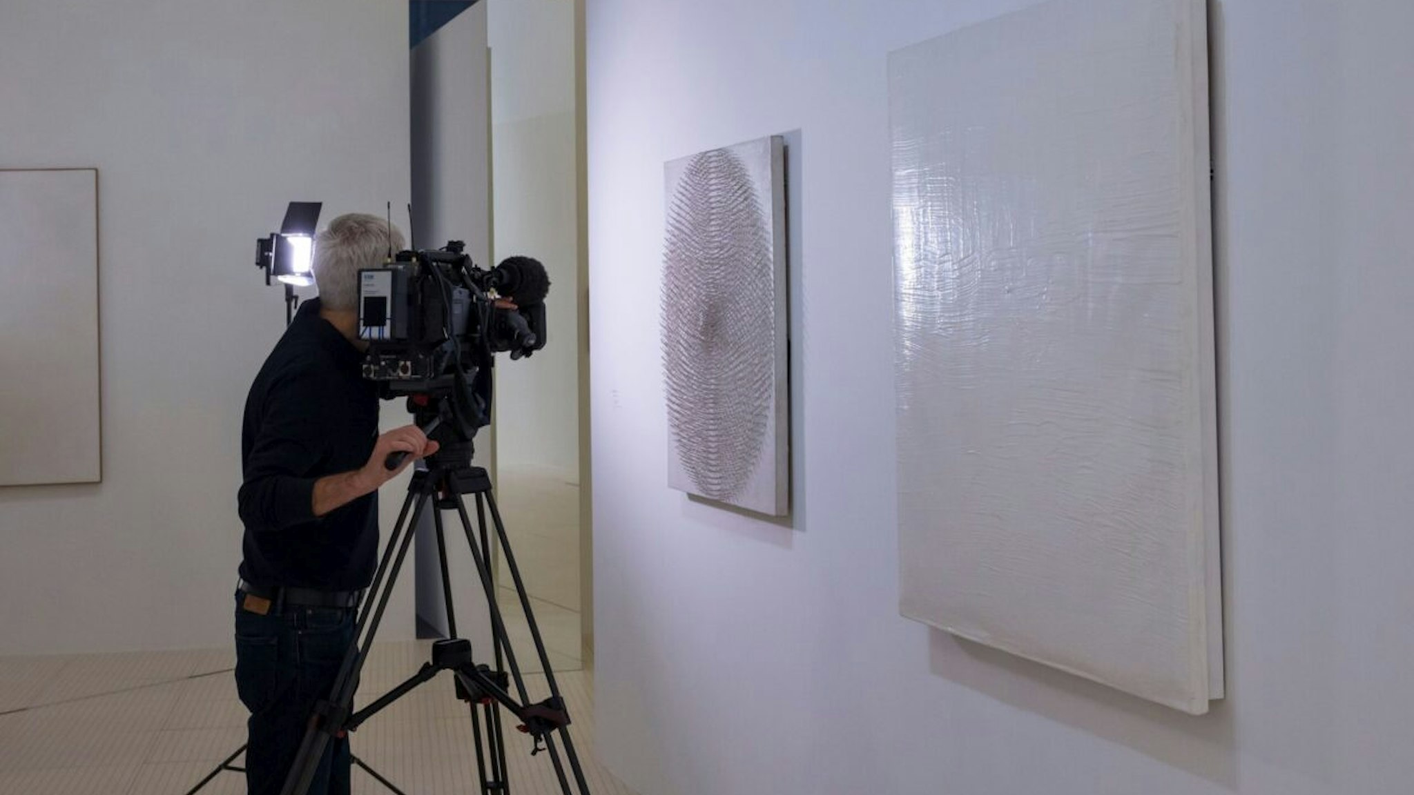 A reporter films "Pure Energy III" (1959) by German artist Otto Piene displayed in the exhibition "Le ciel comme atelier, Yves Klein et ses contemporains" on July 16, 2020 at the Pompidou-Metz museum in Metz, eastern France