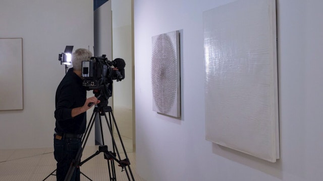 A reporter films "Pure Energy III" (1959) by German artist Otto Piene displayed in the exhibition "Le ciel comme atelier, Yves Klein et ses contemporains" on July 16, 2020 at the Pompidou-Metz museum in Metz, eastern France