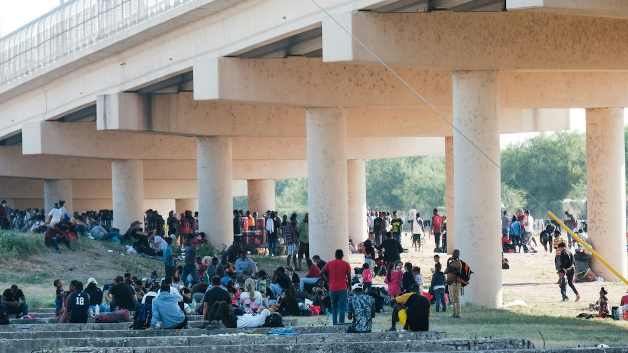 TEXAS, USA - SEPTEMBER 19: Migrants are seen at the Rio Grande near the Del Rio-Acuna Port of Entry in Del Rio, Texas, on September 18, 2021. - The United States said on September 18 that it would ramp up deportation flights for thousands of migrants who flooded into the Texas border city of Del Rio, as authorities scramble to alleviate a burgeoning crisis for President Joe Biden's administration. The migrants who poured into the city, many of them Haitian, were being held in an area controlled by US Customs and Border Protection (CBP) beneath the Del Rio International Bridge, which carries traffic across the Rio Grande river into Mexico. (Photo by Charlie C. Peebles/Anadolu Agency via Getty Images)