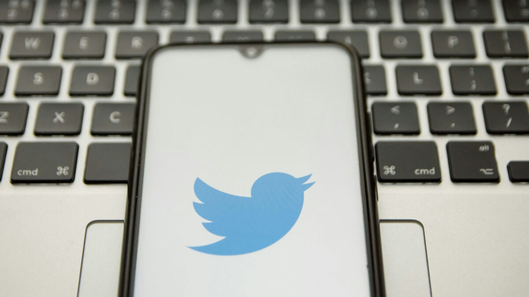 In this photo illustration a Twitter logo seen displayed on a smartphone screen with a computer keyword in the background in Athens, Greece on January 18, 2022.