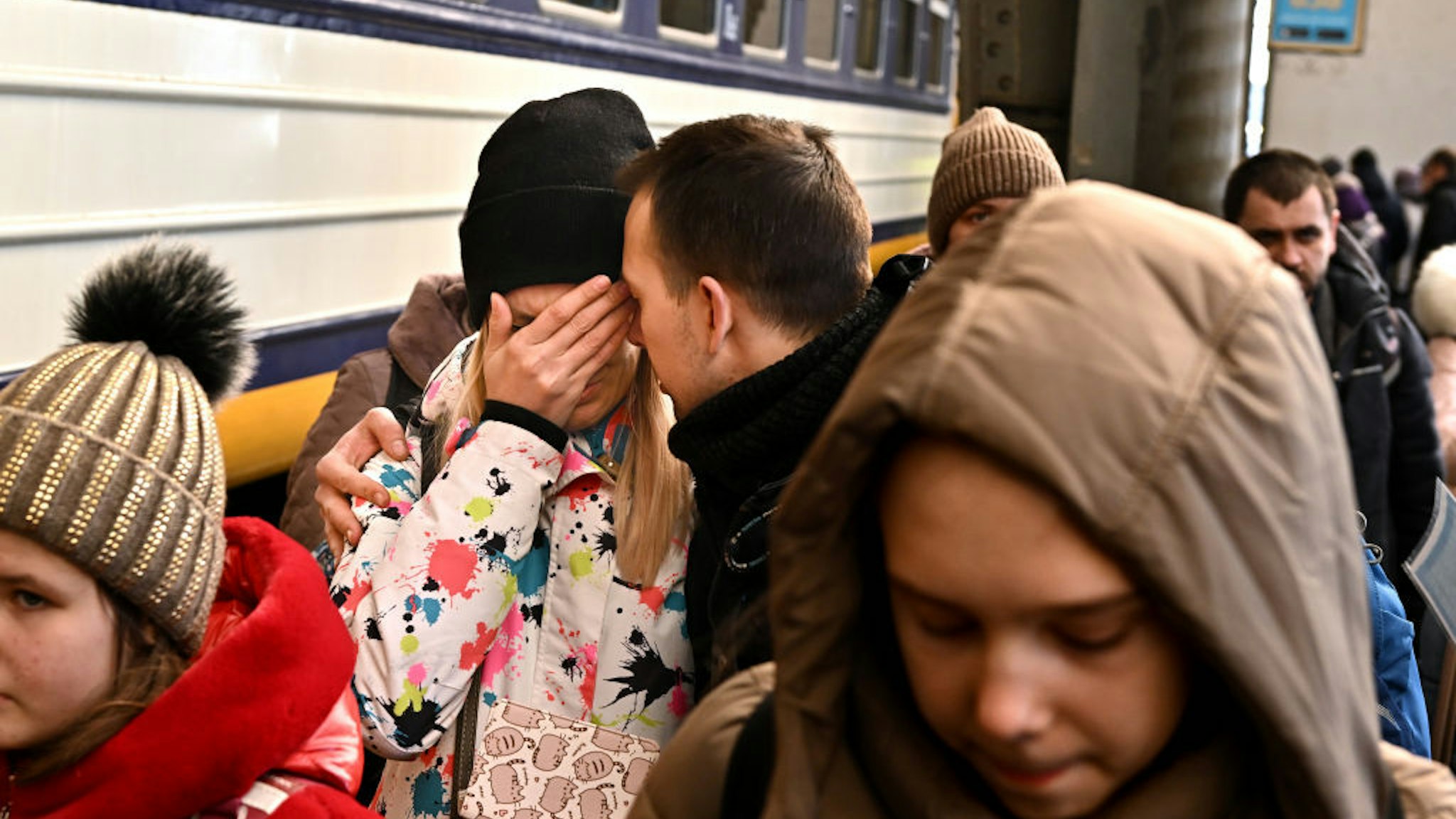 Lviv, Ukraine March 19, 2022: A man comforts his wife in Lviv, Ukraine before she boards a train to Przemysl, Poland. Over two million refugees have fled there towns after the Russians invaded. (Wally Skalij/Los Angeles Times via Getty Images)