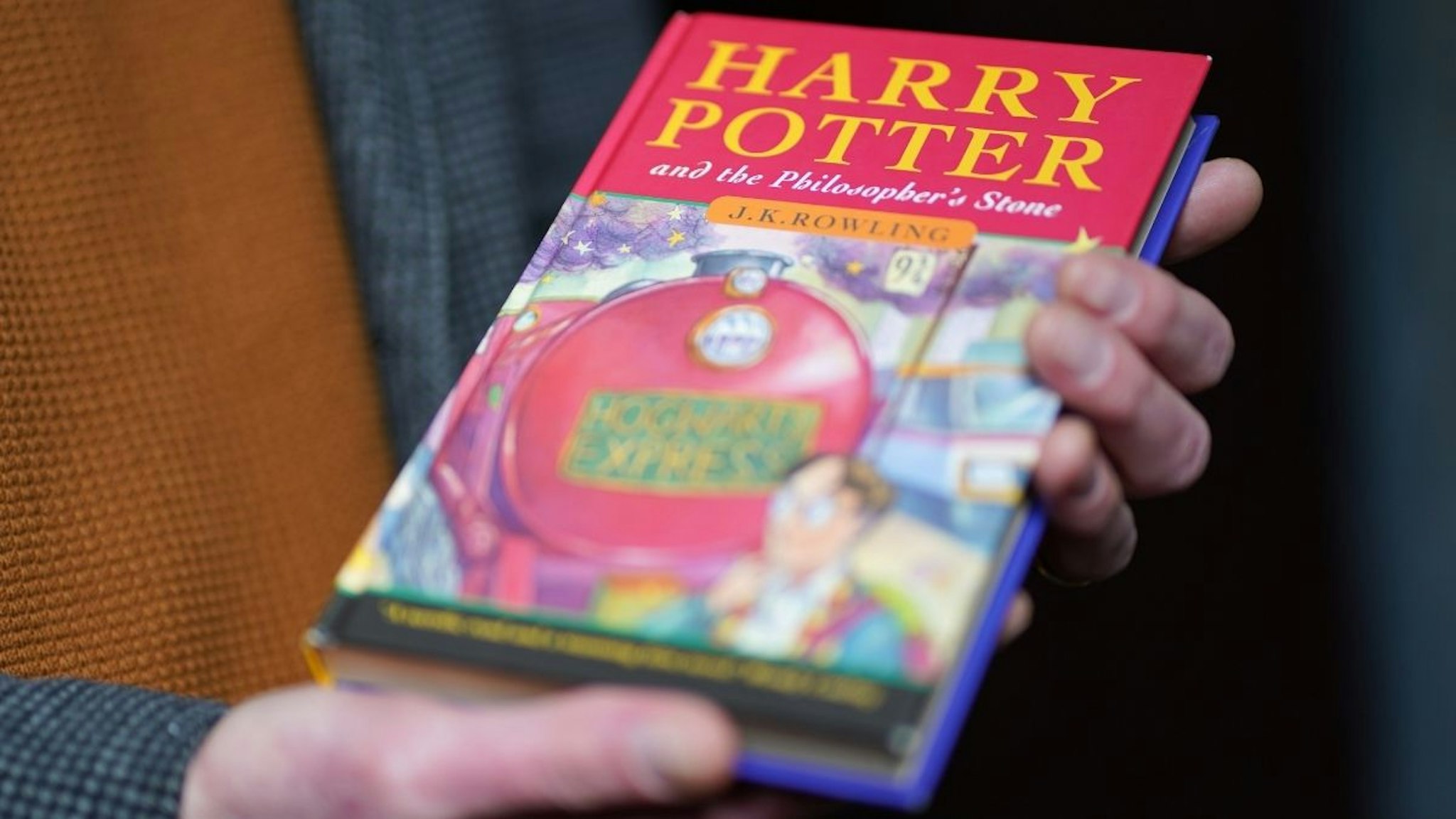 Auctioneer Jim Spencer holds a pristine first edition hardback of JK Rowling's Harry Potter and the Philosopher's Stone, one of only 500 produced in the first print run in 1997, on display at Hansons' Auctioneers at Bishton Hall, Staffordshire.