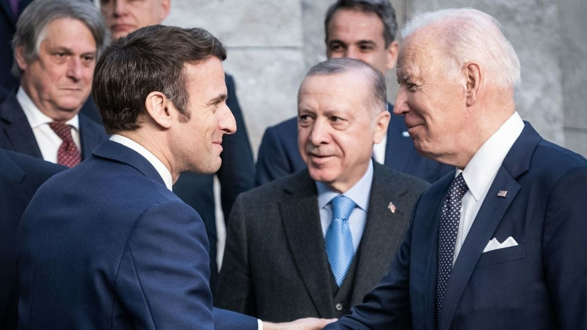 24 March 2022, Belgium, Brüssel: Emmanuel Macron (l), President of France greets Joe Biden, President of the United States, as leaders pose for a family photo before a special NATO summit at NATO headquarters.