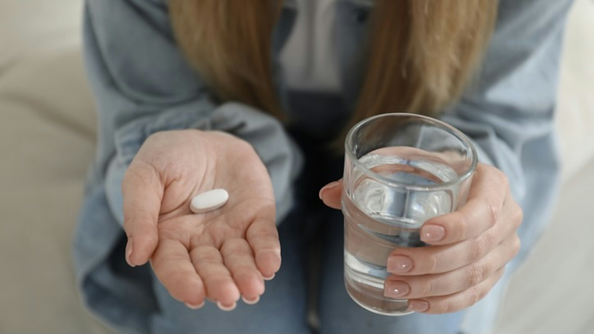 Young woman with abortion pill and glass of water on blurred background, closeup - stock photo Young woman with abortion pill and glass of water on blurred background, closeup Liudmila Chernetska via Getty Images