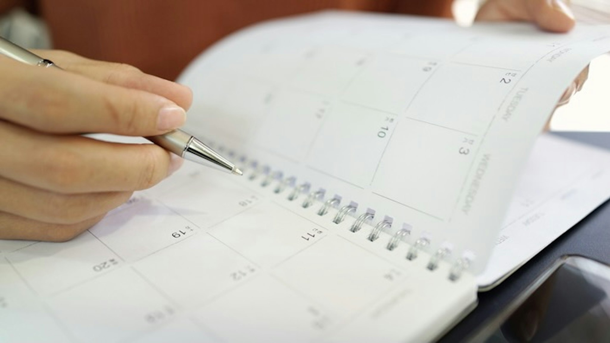 Midsection Of Woman Hand Writing With Pen In Calendar - stock photo Poh Kim Yeoh / EyeEm via Getty Images