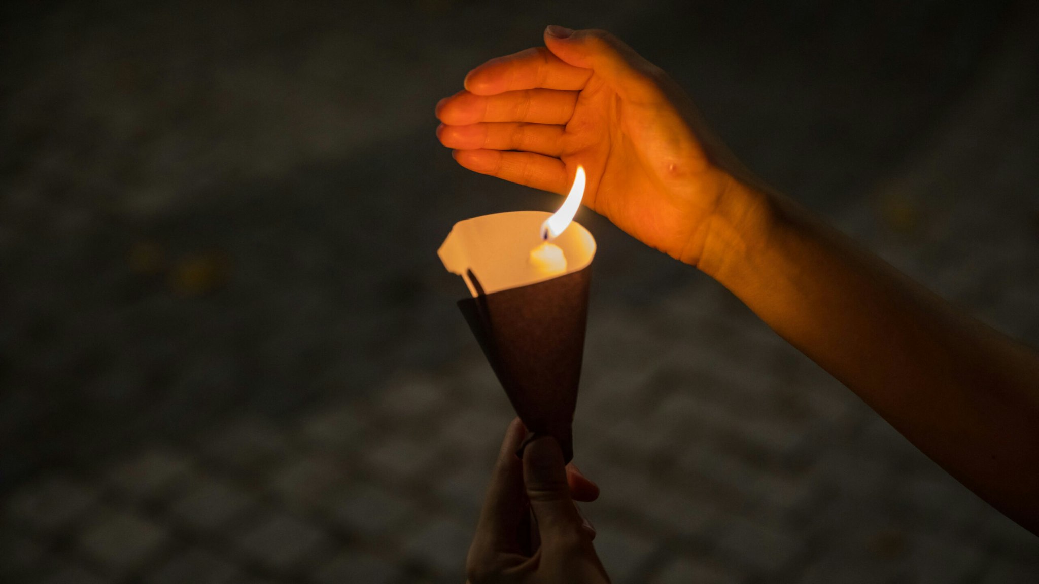 A woman holds a candle during a mass outside a church in Hong Kong on June 4, 2020, to mark the 31st anniversary of the 1989 Tiananmen crackdown in Beijing.