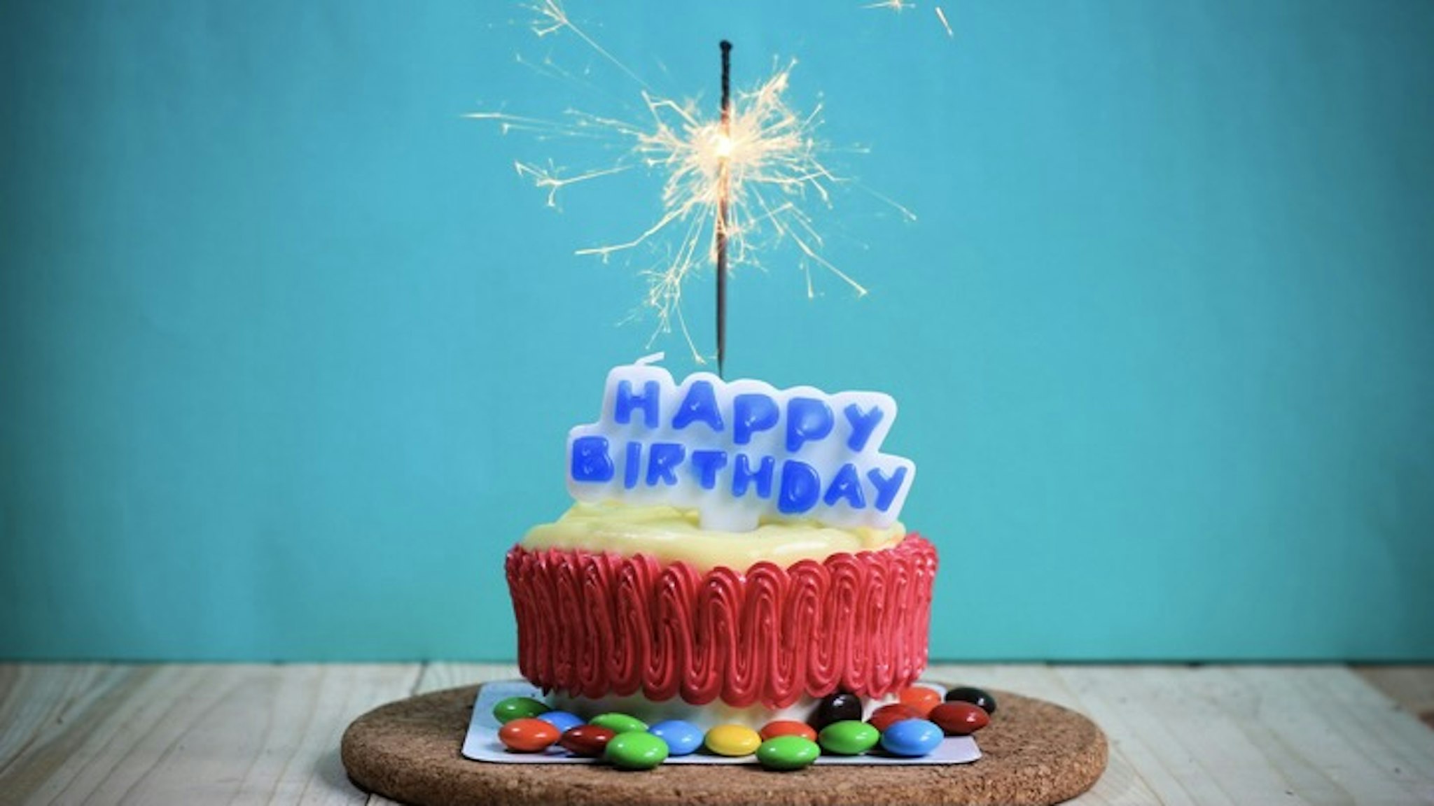 Close-Up Of Birthday Cake On Table Against Turquoise Wall - stock photo Porapak Apichodilok / EyeEm via Getty Images