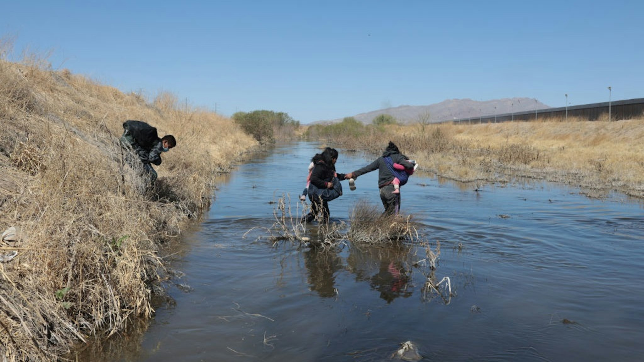UAREZ, CHIHUAHUA, MEXICO - 2021/03/26: A family of Central American migrants crosses the Rio Grande through Ciudad Juarez, the family crossed the river to surrender to the border patrol with the intention of requesting political asylum in the United States.