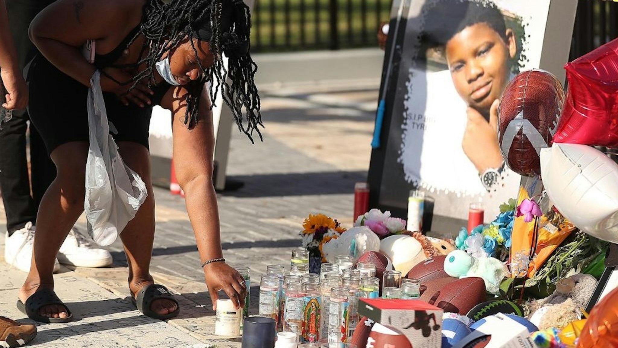 Family members and friends of Tyre Sampson leave items during a vigil in front of the Orlando Free Fall drop tower in ICON Park in Orlando on Monday, March 28, 2022.