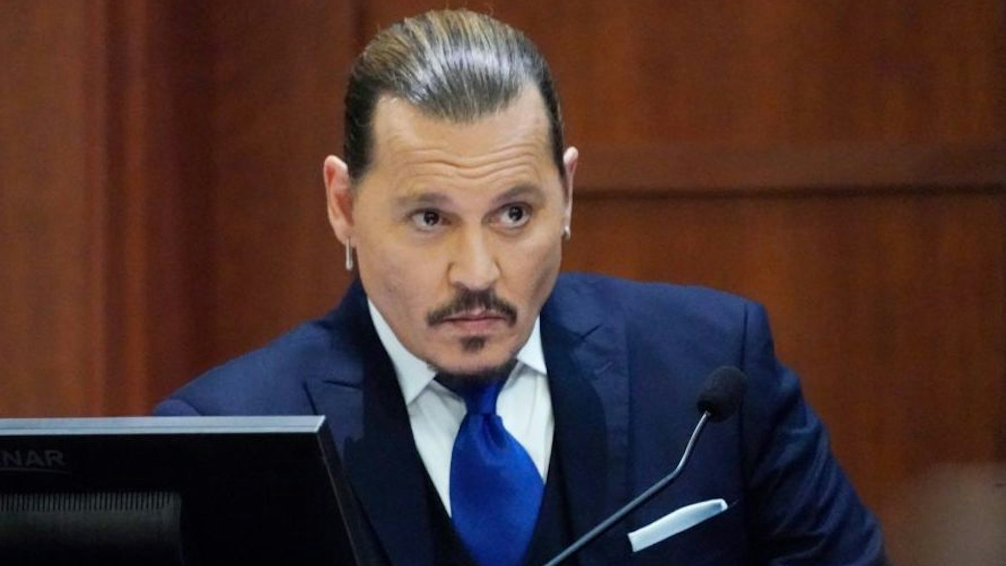 Actor Johnny Depp sits to testify in the courtroom at the Fairfax County Circuit Courthouse in Fairfax, Virginia, April 25, 2022.