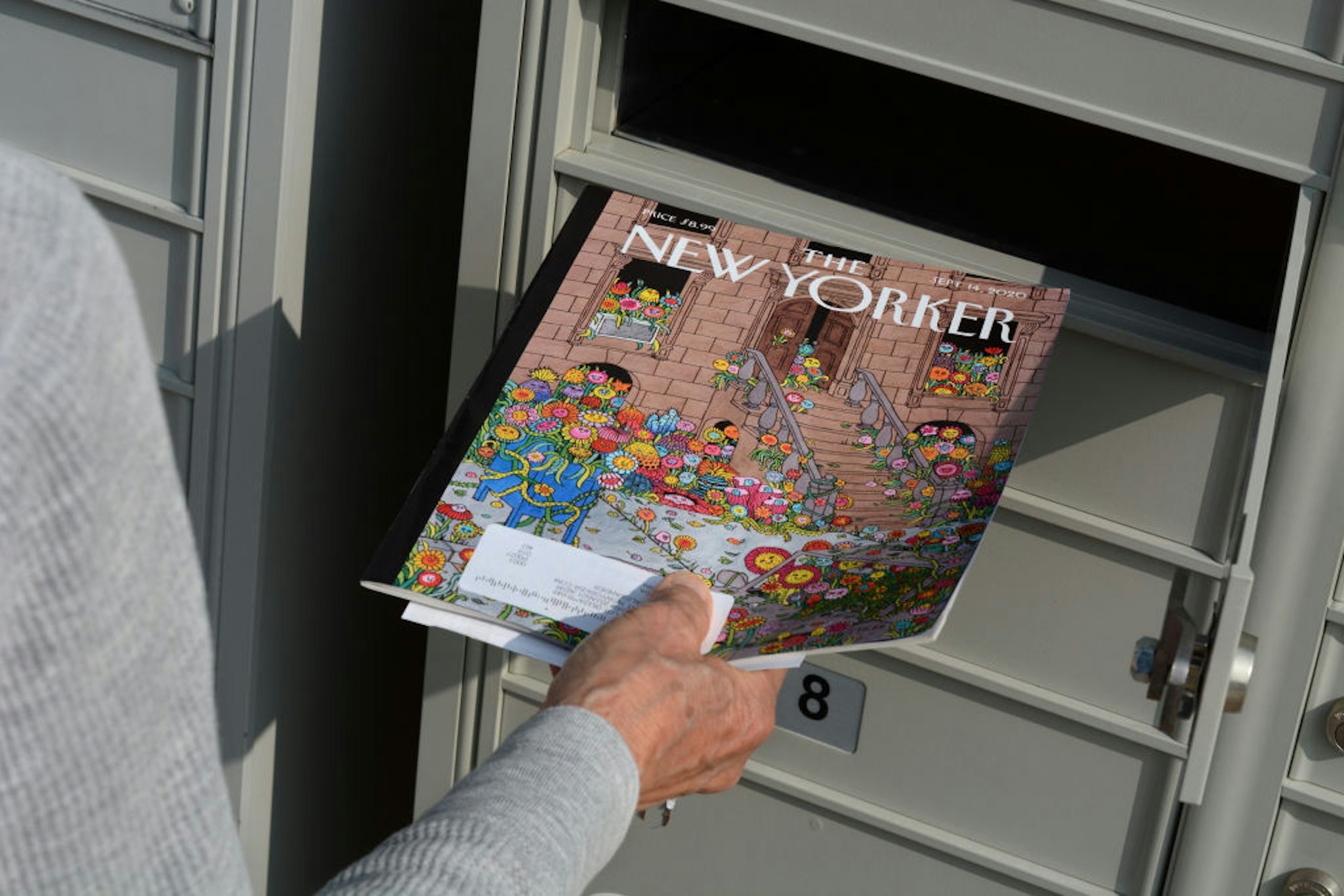 SANTA FE, NEW MEXICO - FEBRUARY 8, 2020: A woman retrieves a copy of The New Yorker magazine from her condominium cluster mailbox in Santa Fe, New Mexico.