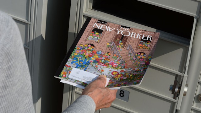SANTA FE, NEW MEXICO - FEBRUARY 8, 2020: A woman retrieves a copy of The New Yorker magazine from her condominium cluster mailbox in Santa Fe, New Mexico.