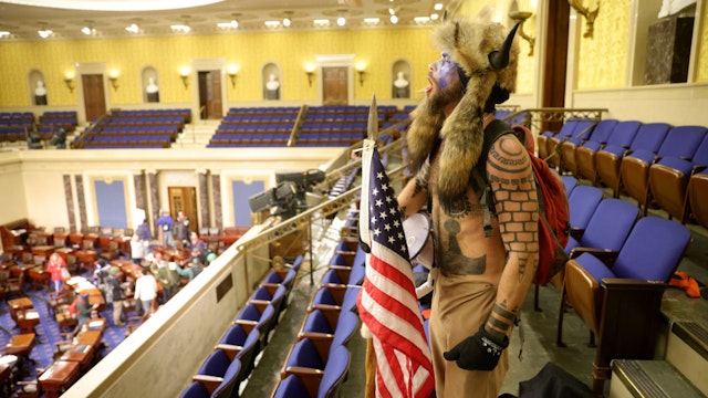 WASHINGTON, DC - JANUARY 06: A protester yells inside the Senate Chamber on January 06, 2021 in Washington, DC. Congress held a joint session today to ratify President-elect Joe Biden's 306-232 Electoral College win over President Donald Trump. Pro-Trump protesters entered the U.S. Capitol building during mass demonstrations in the nation's capital.