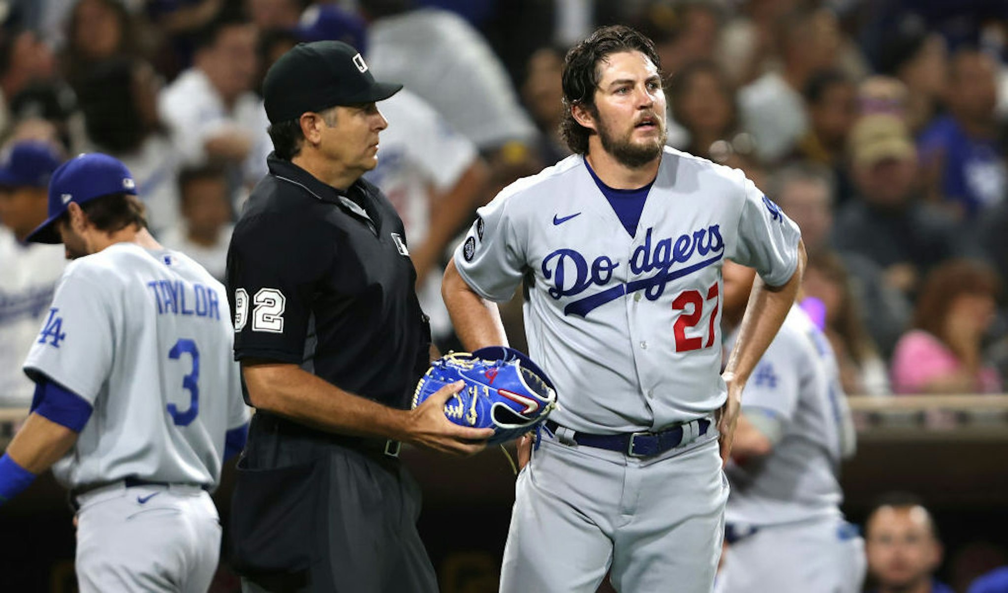 SAN DIEGO, CALIFORNIA - JUNE 23: Homeplate umpire James Hoye #92 checks the glove of Trevor Bauer #27 of the Los Angeles Dodgers during the fourth inning of a game against the Los Angeles Dodgers at PETCO Park on June 23, 2021 in San Diego, California. (Photo by Sean M. Haffey/Getty Images)