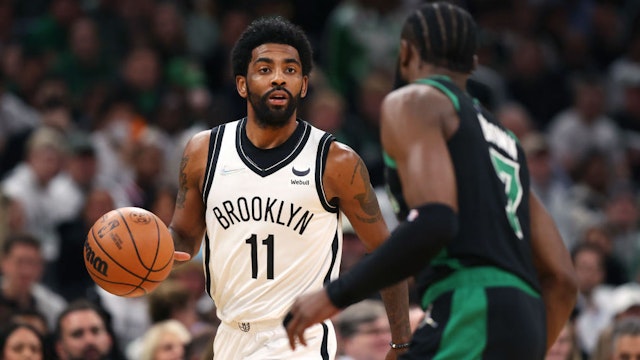 BOSTON, MASSACHUSETTS - APRIL 17: Kyrie Irving #11 of the Brooklyn Nets dribbles downcourt against Jaylen Brown #7 of the Boston Celtics during the first quarter of Round 1 Game 1 of the 2022 NBA Eastern Conference Playoffs at TD Garden on April 17, 2022 in Boston, Massachusetts. (Photo by Maddie Meyer/Getty Images)