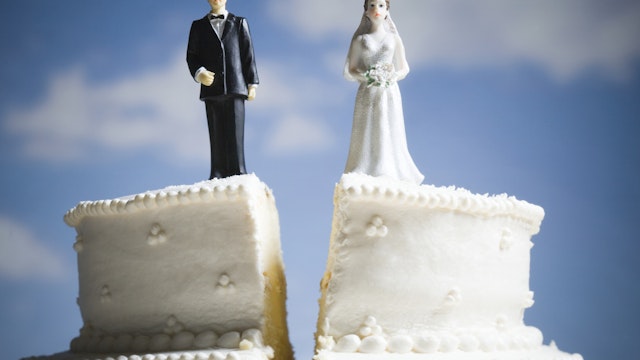 Wedding cake visual metaphor with figurine cake toppers - stock photo