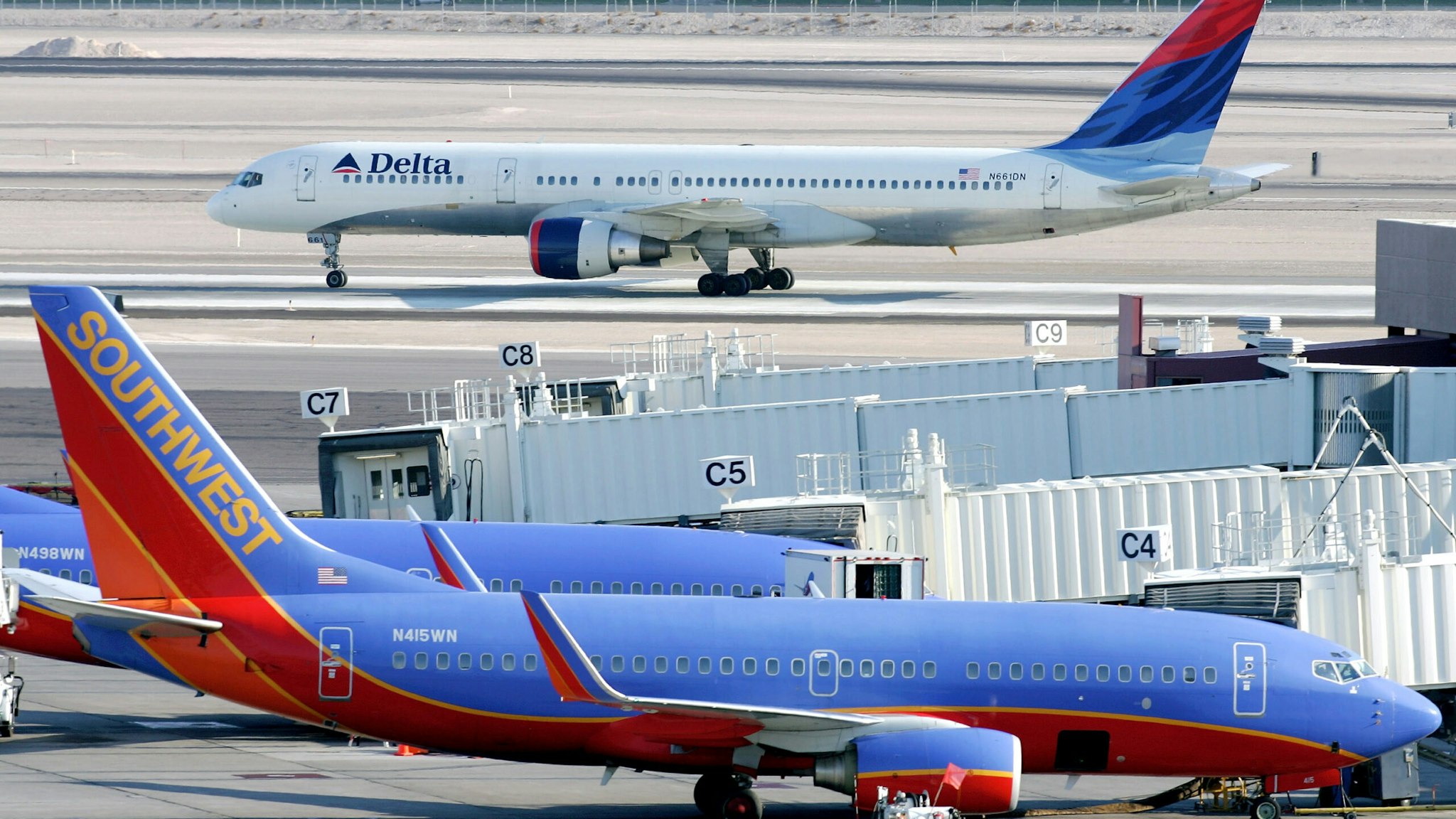 LAS VEGAS - SEPTEMBER 12: A Delta Air Lines jet taxis beyond parked Southwest Airlines planes at McCarran International Airport September 12, 2005 in Las Vegas, Nevada. Delta's stock plunged more than 22% to an all-time low today amid reports that it might file for bankruptcy protection as early as this week.