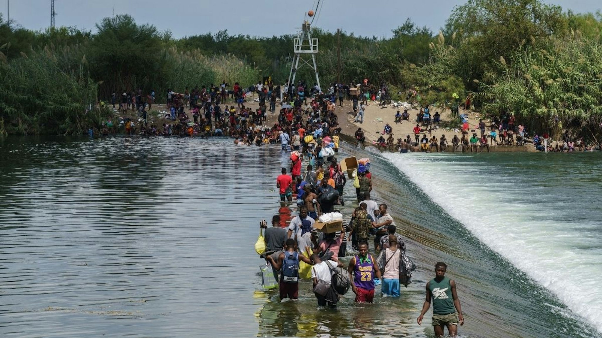 Migrants, many of them Haitian, cross the Rio Grande to get food and supplies near the Del Rio-Acuna Port of Entry in Ciudad Acuna, Coahuila state, Mexico on September 18, 2021.