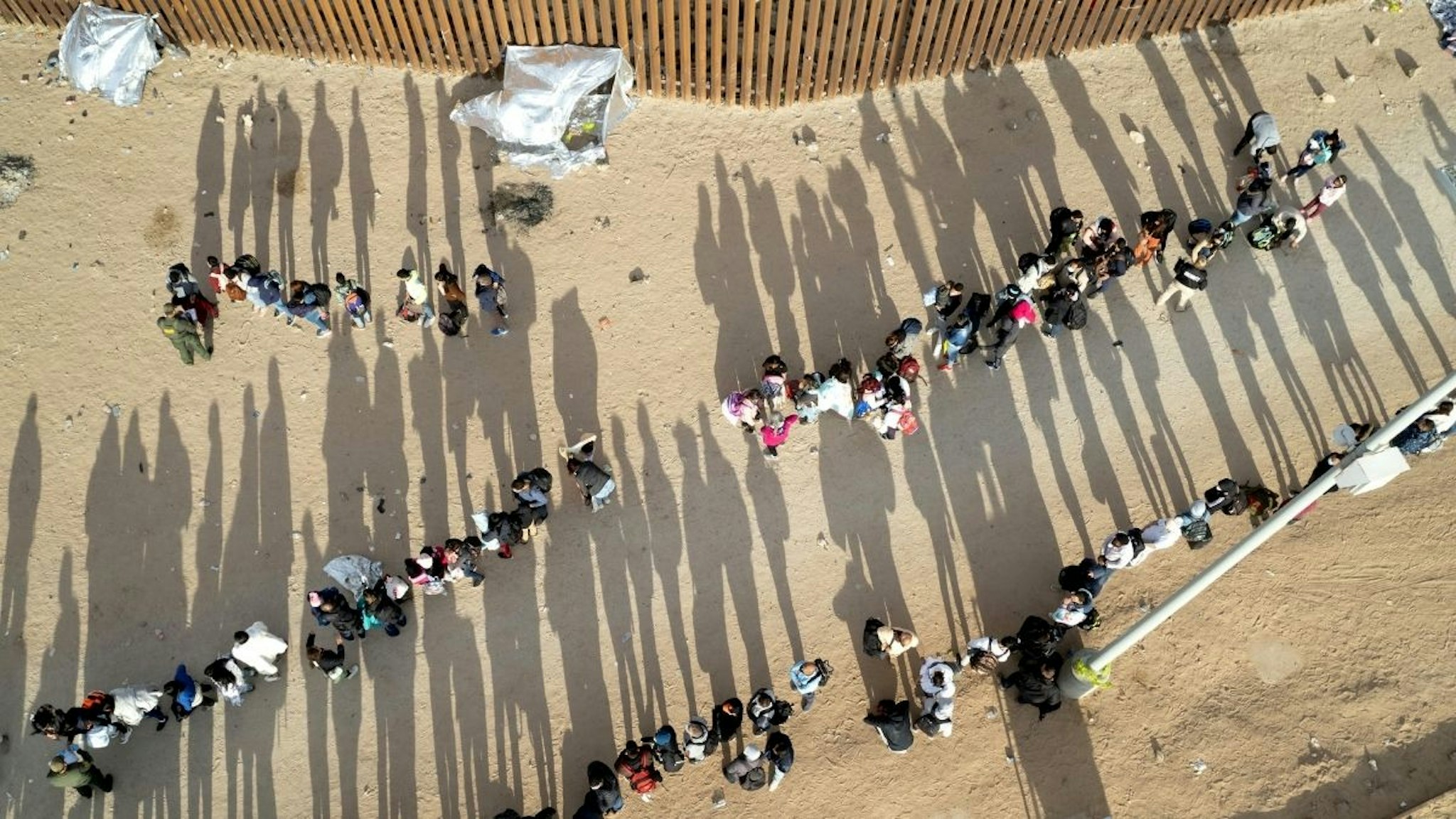 In an aerial view, immigrant families are taken into custody by U.S. Border Patrol agents at the U.S.-Mexico border on December 07, 2021 in Yuma, Arizona.
