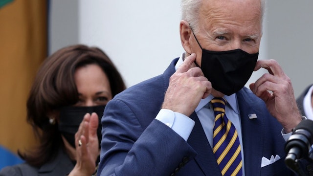 U.S. President Joe Biden (R) takes off his mask as Vice President Kamala Harris (L) looks on during an event on the American Rescue Plan in the Rose Garden of the White House on March 12, 2021 in Washington, DC.