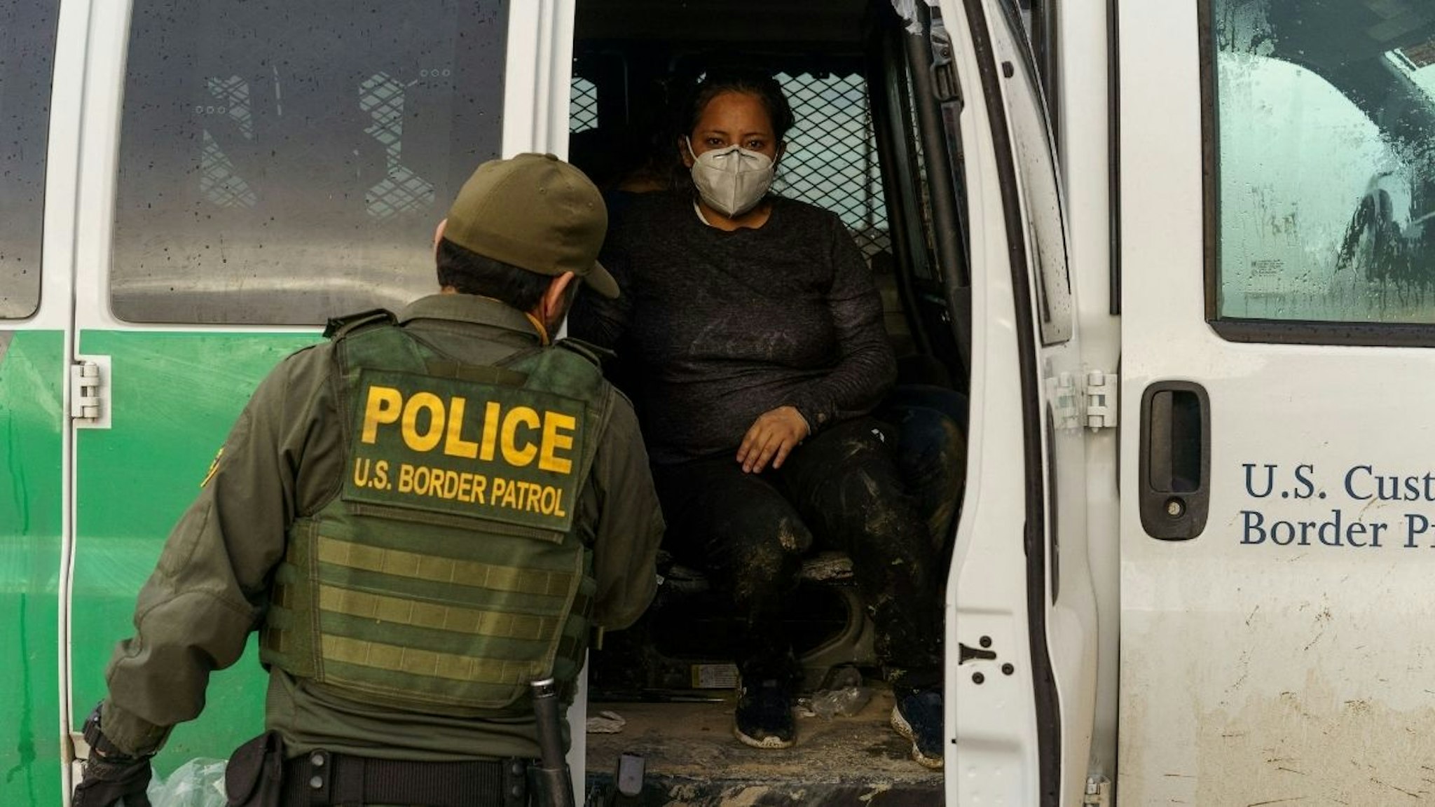 An Ecuadorian woman (C) is pictured in a United States Border Patrol transport vehicle in Sunland Park, New Mexico on September 1, 2021.
