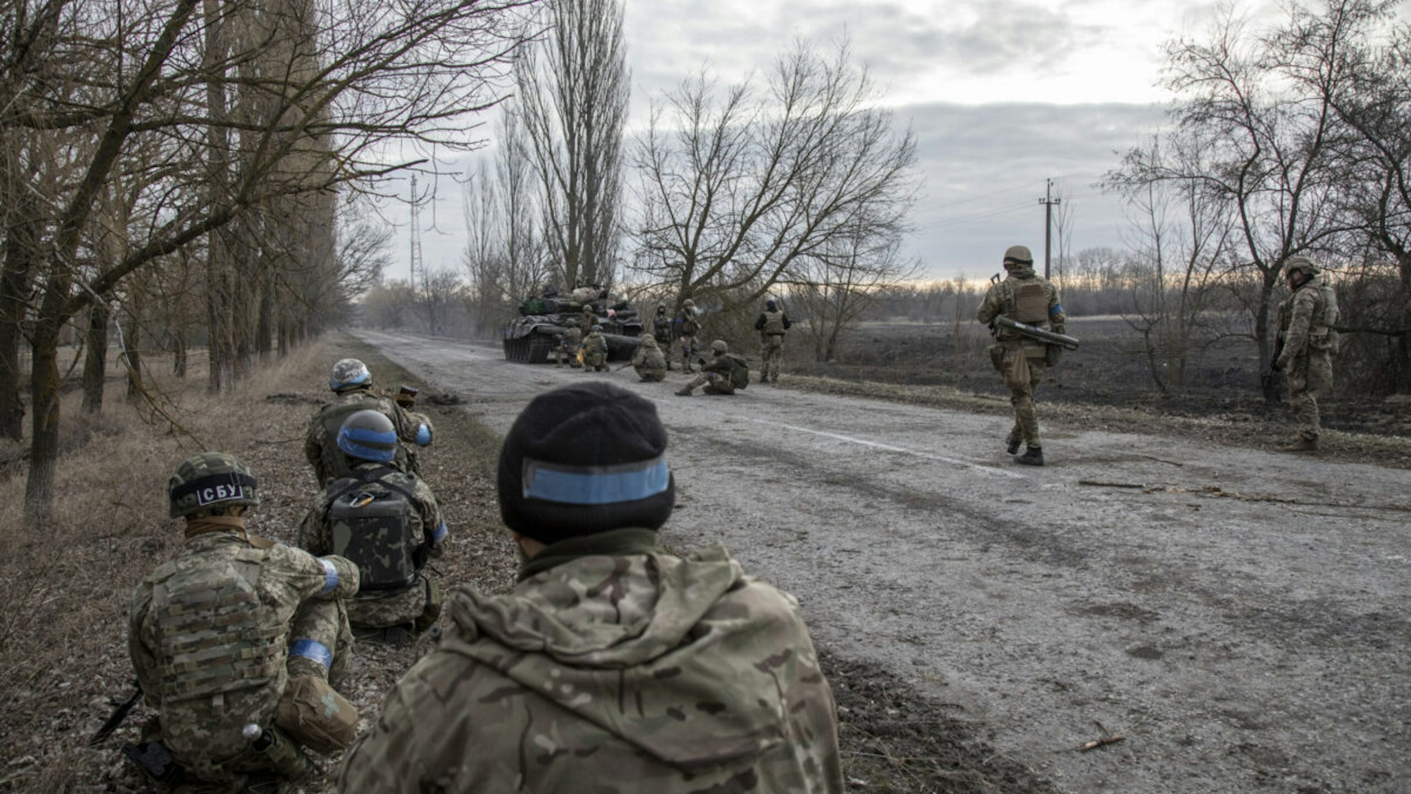 Ukrainian army servicemen and Territorial Defense Force units take cover behind military armored vehicles as they advance to the battlefield to fight against Russian army in Lukâyanivka frontline, eastern of Kyiv, Ukraine, March 28th, 2022