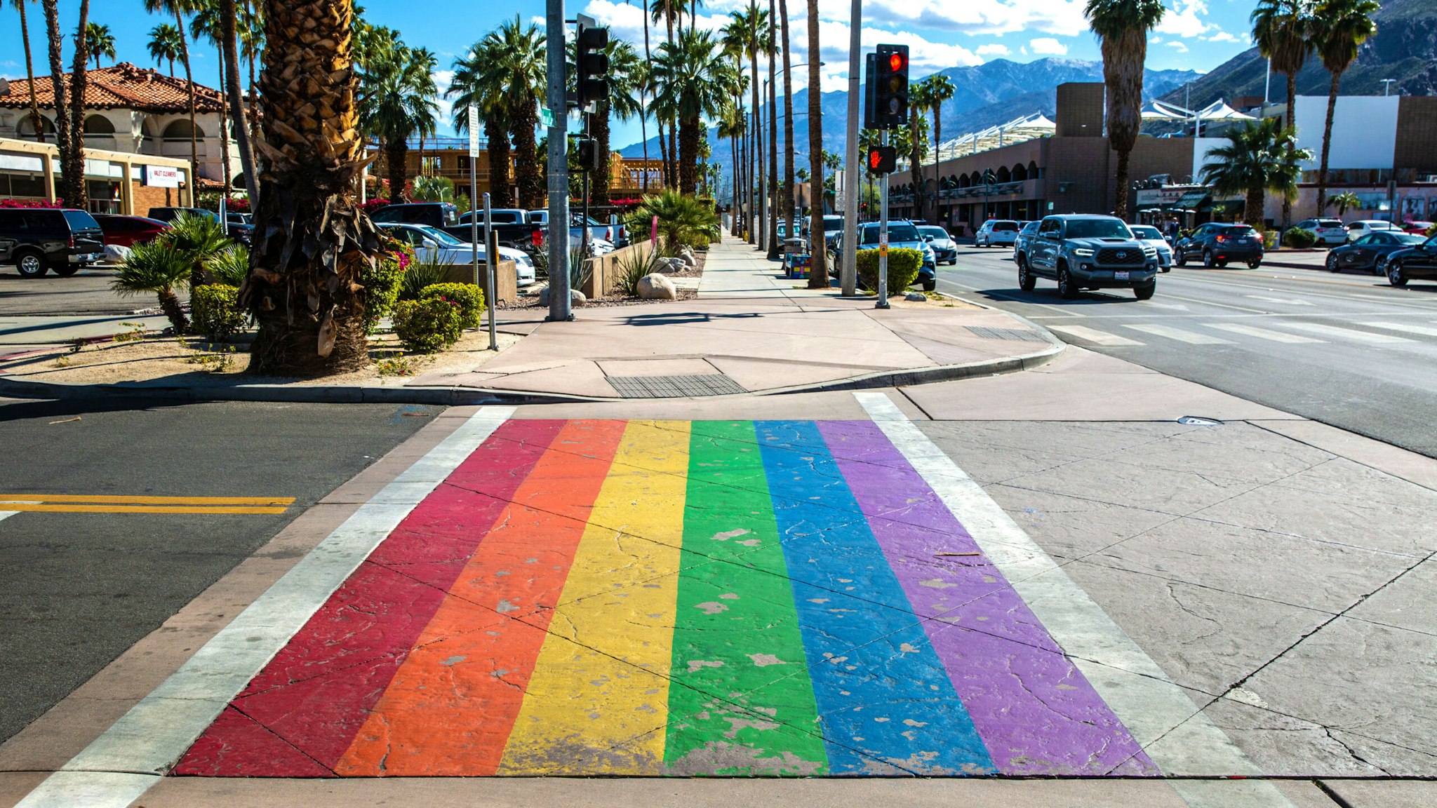 PALM SPRINGS, CA - MARCH 7: The street pedestrian crossing is painted in rainbow colors as viewed on March 7, 2022 in Palm Springs, California. Palm Springs is a city of nearly 50,000 that has become an important tourist destination for the LGBTQ community as well as a relaxed environment for older retirees. This desert resort city is located 2 hours east of Los Angeles in Riverside County within the Colorado Desert's Coachella Valley.