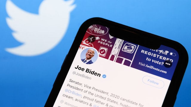 Twitter feed of candidate for President of the USA Joe Biden is seen displayed on a phone screen with Twitter logo in the background in this illustration photo taken on October 18, 2020.