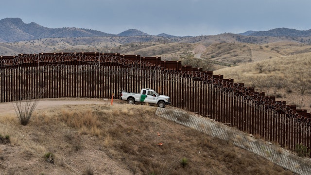 A Border Patrol officer sits inside his car as he guards the US/Mexico border fence, in Nogales, Arizona, on February 9, 2019.
