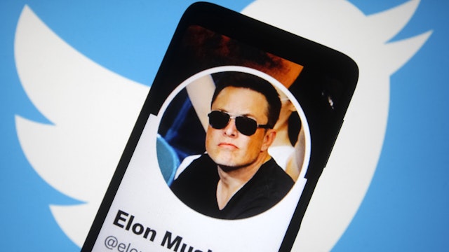 UKRAINE - 2022/04/26: In this photo illustration, Twitter account of Elon Musk is seen on a smartphone screen and Twitter logo in the background.