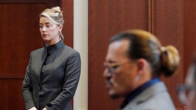 Actors Amber Heard and Johnny Depp watch as the jury leave the courtroom for a lunch break at the Fairfax County Circuit Courthouse in Fairfax, Virginia, on May 16, 2022. - Actor Johnny Depp sued his ex-wife Amber Heard for libel in Fairfax County Circuit Court after she wrote an op-ed piece in The Washington Post in 2018 referring to herself as a "public figure representing domestic abuse." (Photo by Steve Helber / POOL / AFP) (Photo by STEVE HELBER/POOL/AFP via Getty Images)