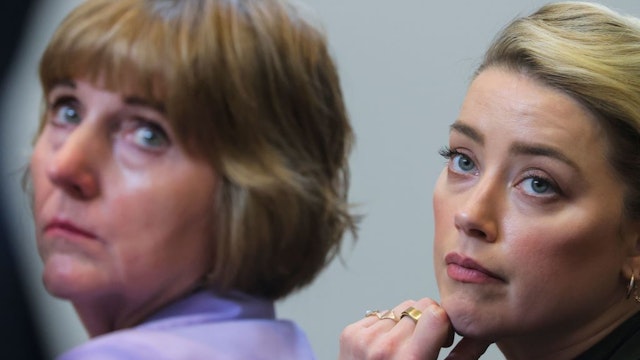 Actor Amber Heard and her attorney Elaine Bredehoft listen to actor Johnny Depp's testimony during his defamation trial against her, at the Fairfax County Circuit Courthouse in Fairfax, Virginia, on May 25, 2022.