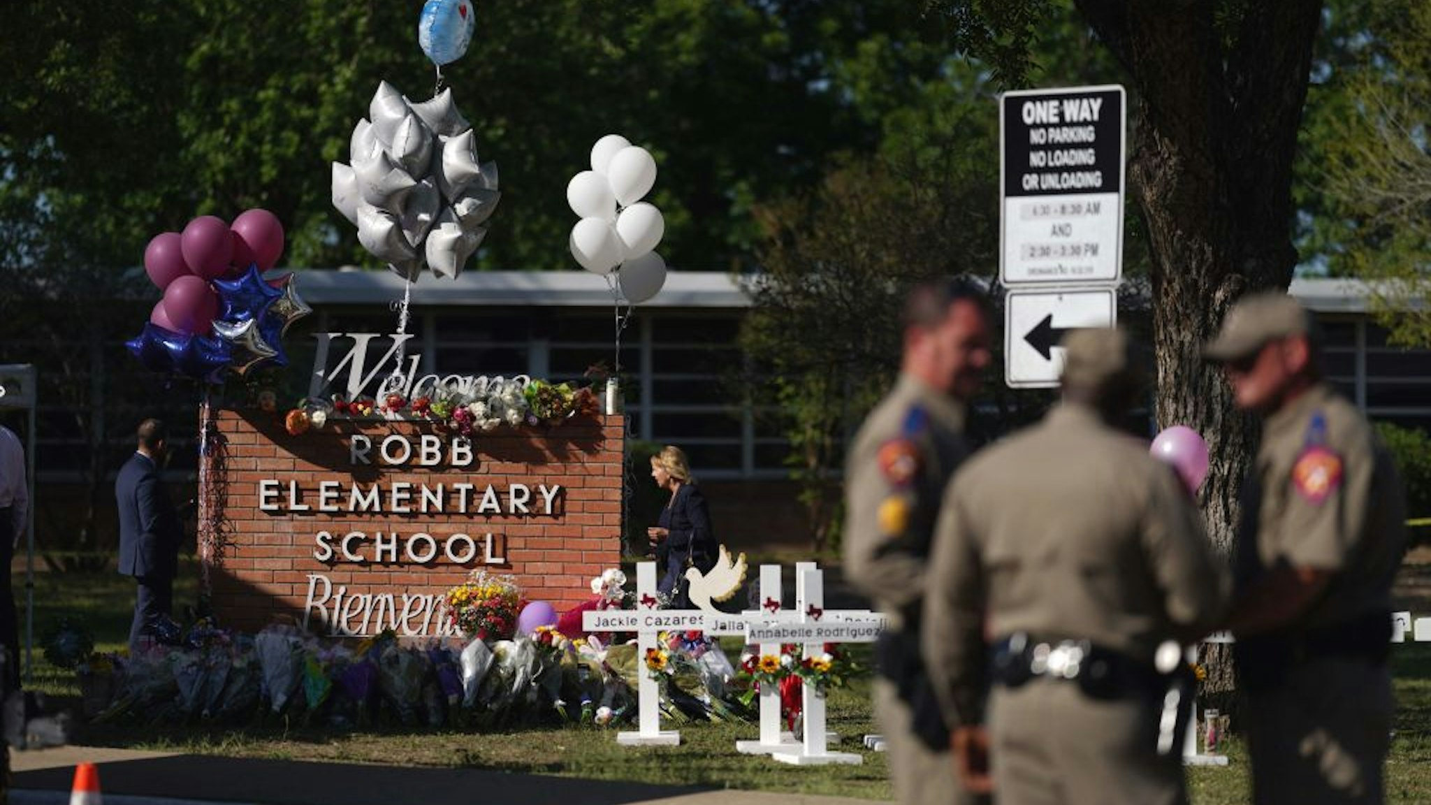 Police officers stand next to a makeshift memorial outside the Robb Elementary School on May 26, 2022 in Uvalde, Texas. - Grief at the massacre of 19 children at the elementary school in Texas spilled into confrontation on May 25, as angry questions mounted over gun control -- and whether this latest tragedy could have been prevented. The tight-knit Latino community of Uvalde on May 24 became the site of the worst school shooting in a decade, committed by a disturbed 18-year-old armed with a legally bought assault rifle. (Photo by allison dinner / AFP) (Photo by ALLISON DINNER/AFP via Getty Images)