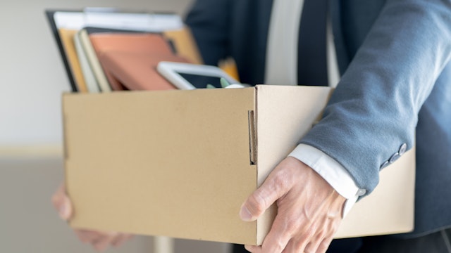 Midsection Of Businessman Carrying Cardboard Box - stock photo