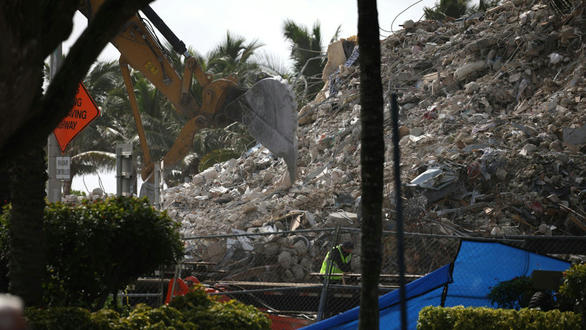 Excavators dig through the pile of debris from the collapsed 12-story Champlain Towers South condo building following a severe thunderstorm on July 13, 2021 in Surfside, Florida.