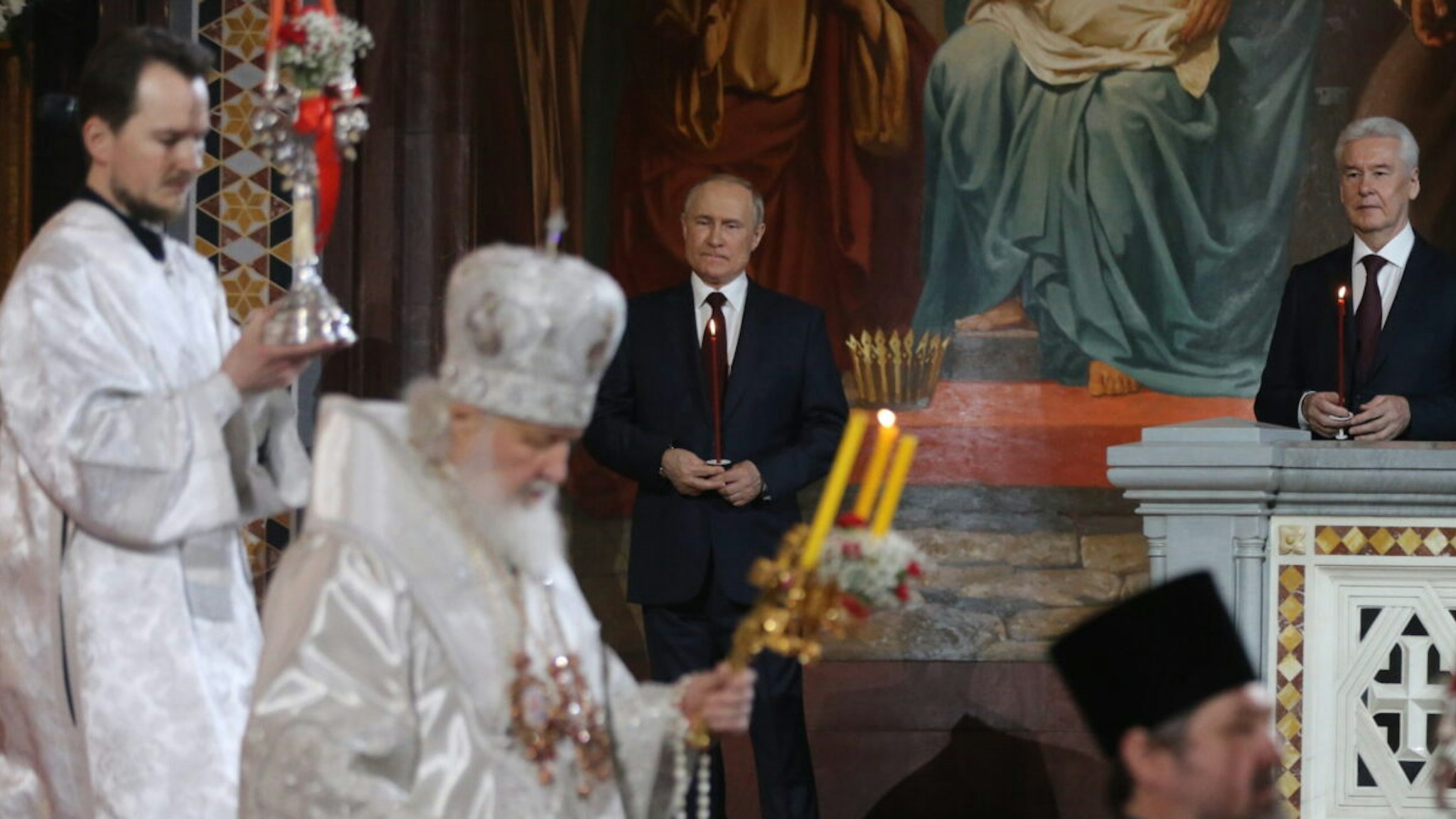 Russian President Vladimir Putin (C) and Moscow's Mayor Sergei Sobyanin (R) attend Orthodox Easter mass led by Russian Orthodox Patriarch Kirill at the Christ The Saviour Cathedral on April 24, 2022 in Moscow, Russia