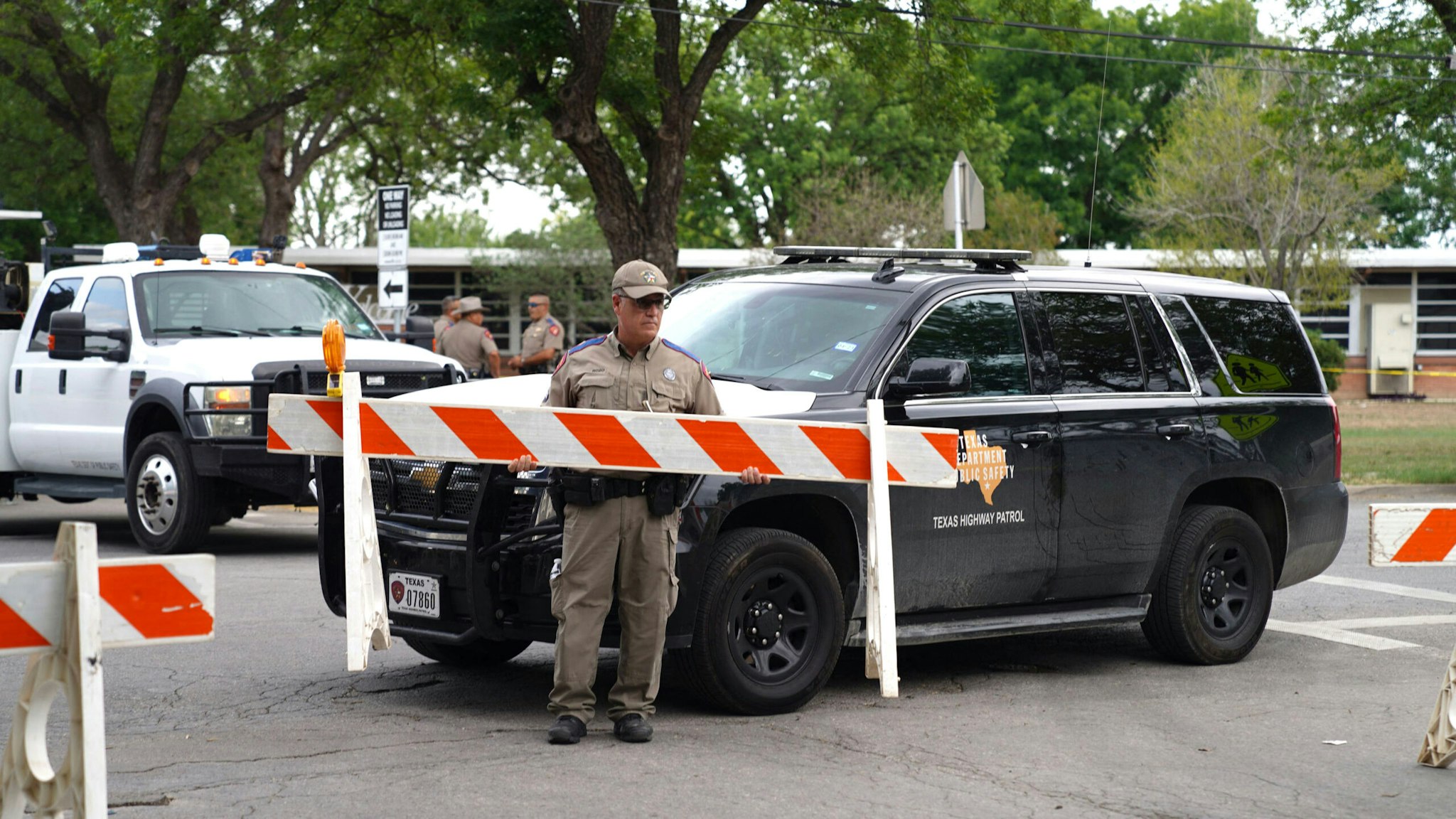 A state trooper sets up barricades outside of Robb Elementary School in Uvalde, Texas, on May 24, 2022. - An 18-year-old gunman killed 14 children and a teacher at an elementary school in Texas on Tuesday, according to the state's governor, in the nation's deadliest school shooting in years.
