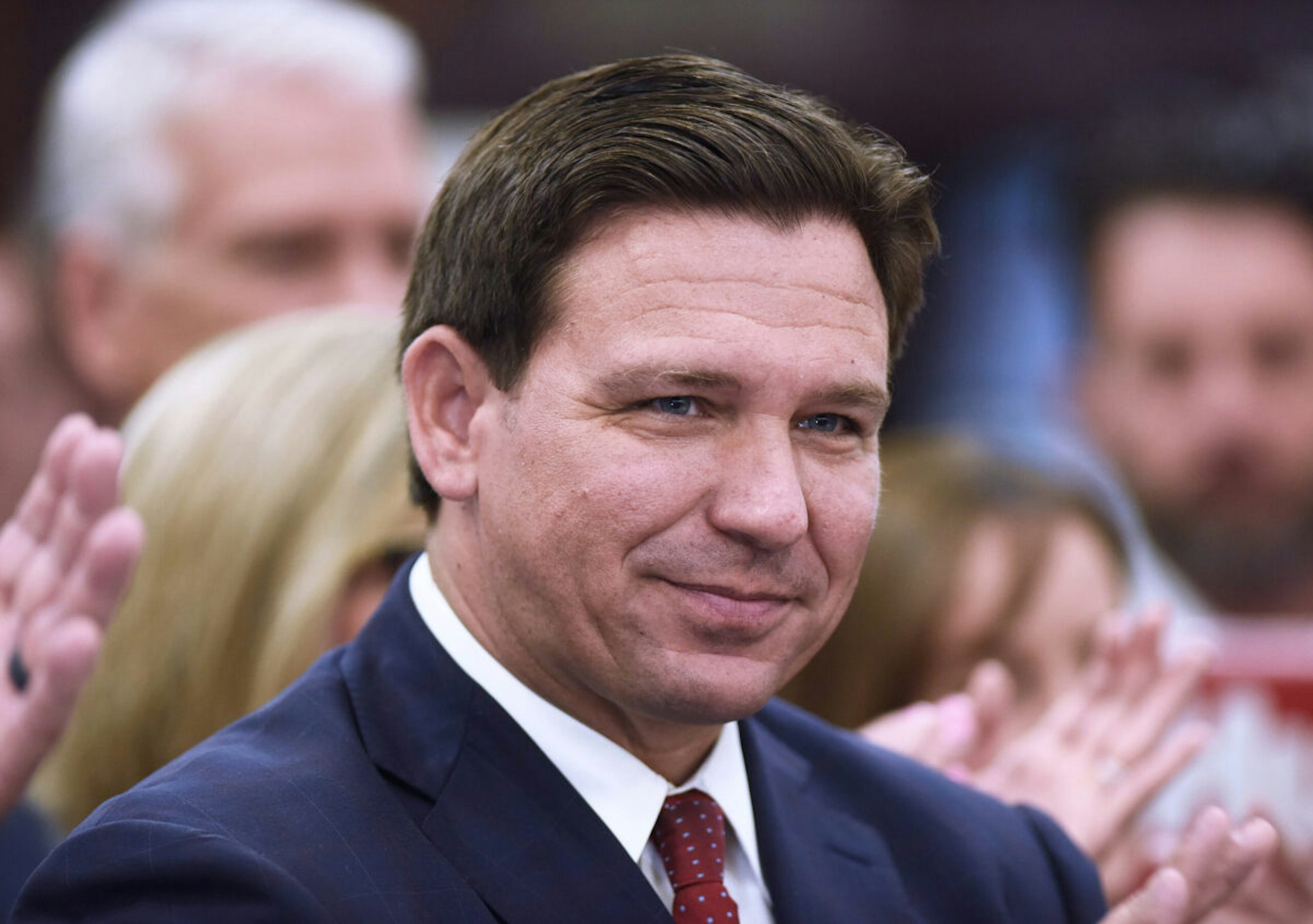 Florida Governor Ron DeSantis listens to a speaker at a press conference at Club in Ocala, where he signed into law more than $1.2 billion in tax relief for Floridians, the largest tax relief package in Florida