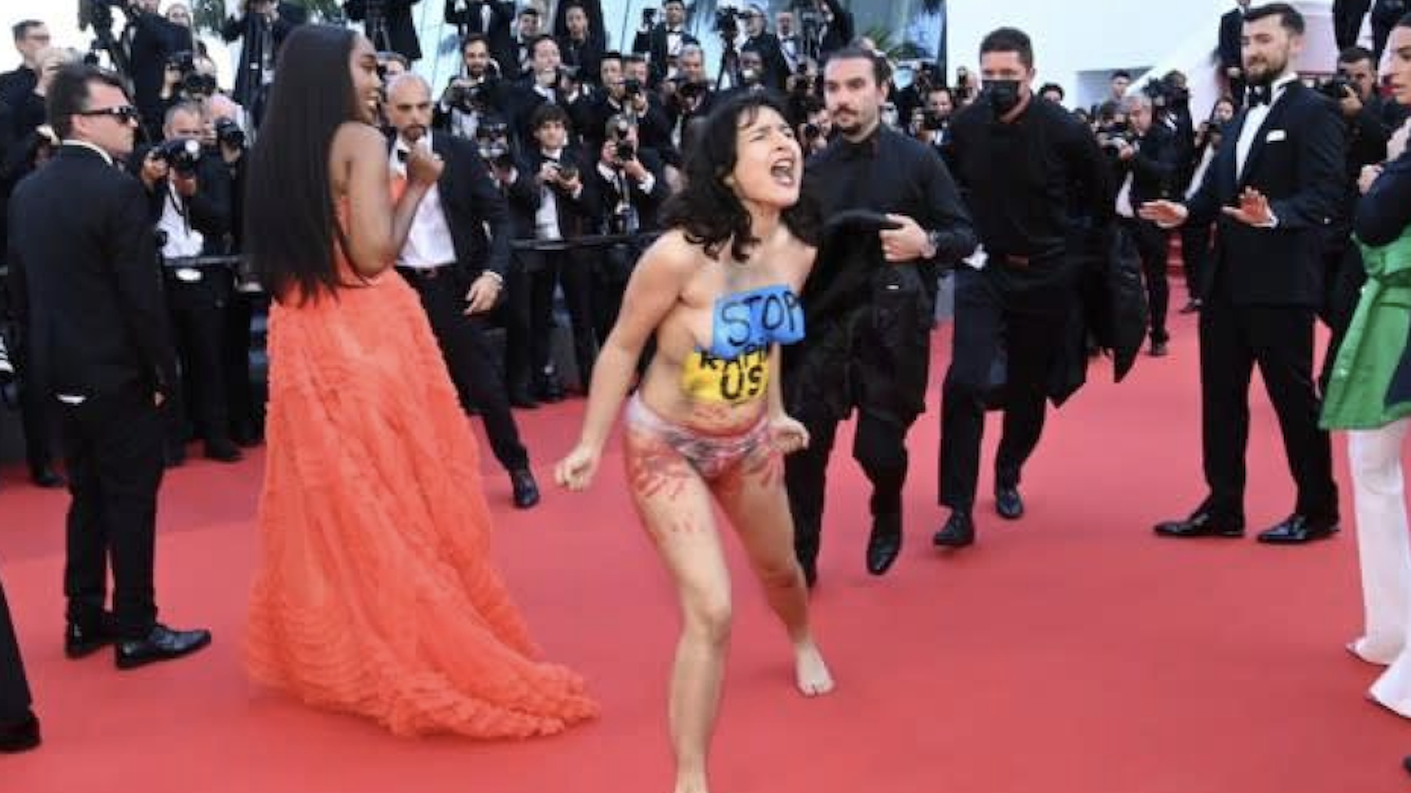 A topless protester yelling "Don't rape us" interrupted a red carpet at Cannes