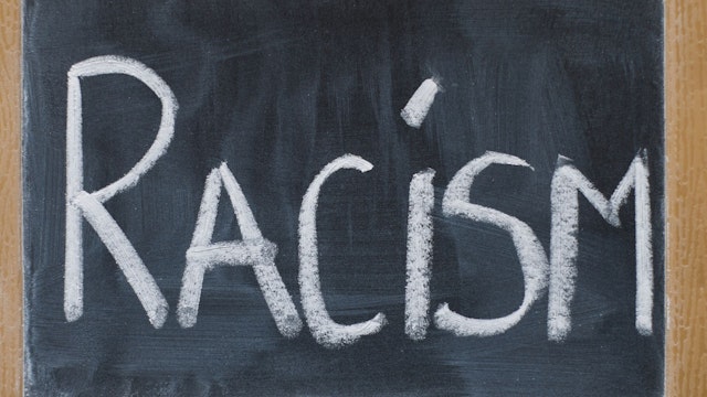 Chalkboard shows the word "racism."