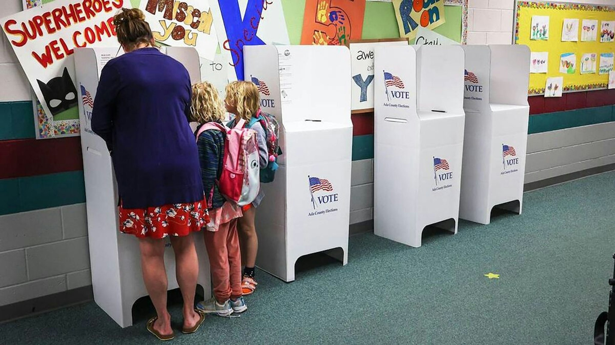 Leslie Hayes votes with twin daughters Adelayde and Zoey, 7, who watch with abundant curiosity May 17, 2022, at a Boise, Idaho, precinct.