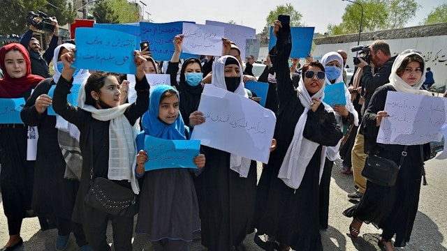 Afghan women and girls take part in a protest in front of the Ministry of Education in Kabul on March 26, 2022, demanding that high schools be reopened for girls.