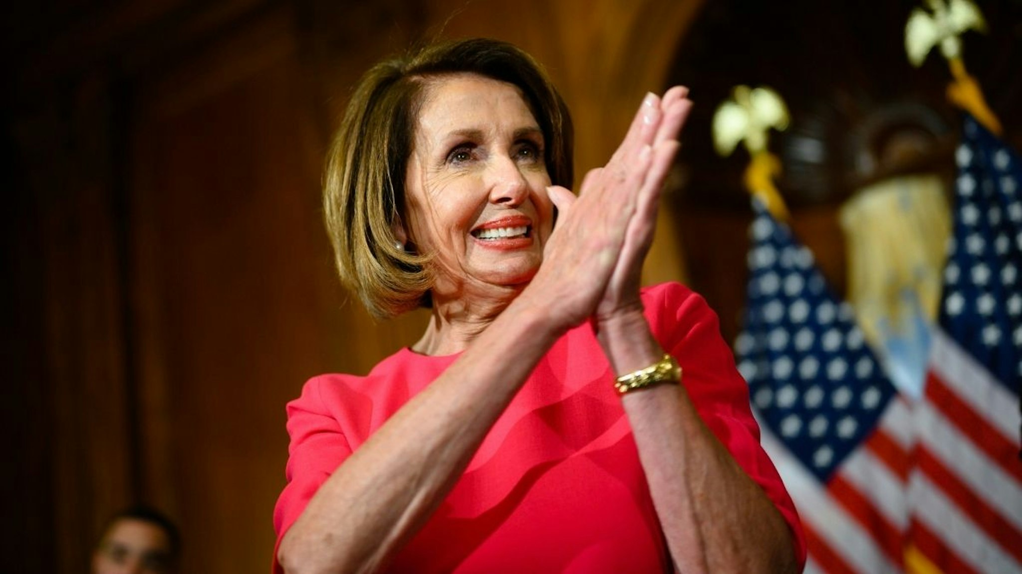 House Speaker Nancy Pelosi of California applauds all the staffers at the end of the event.