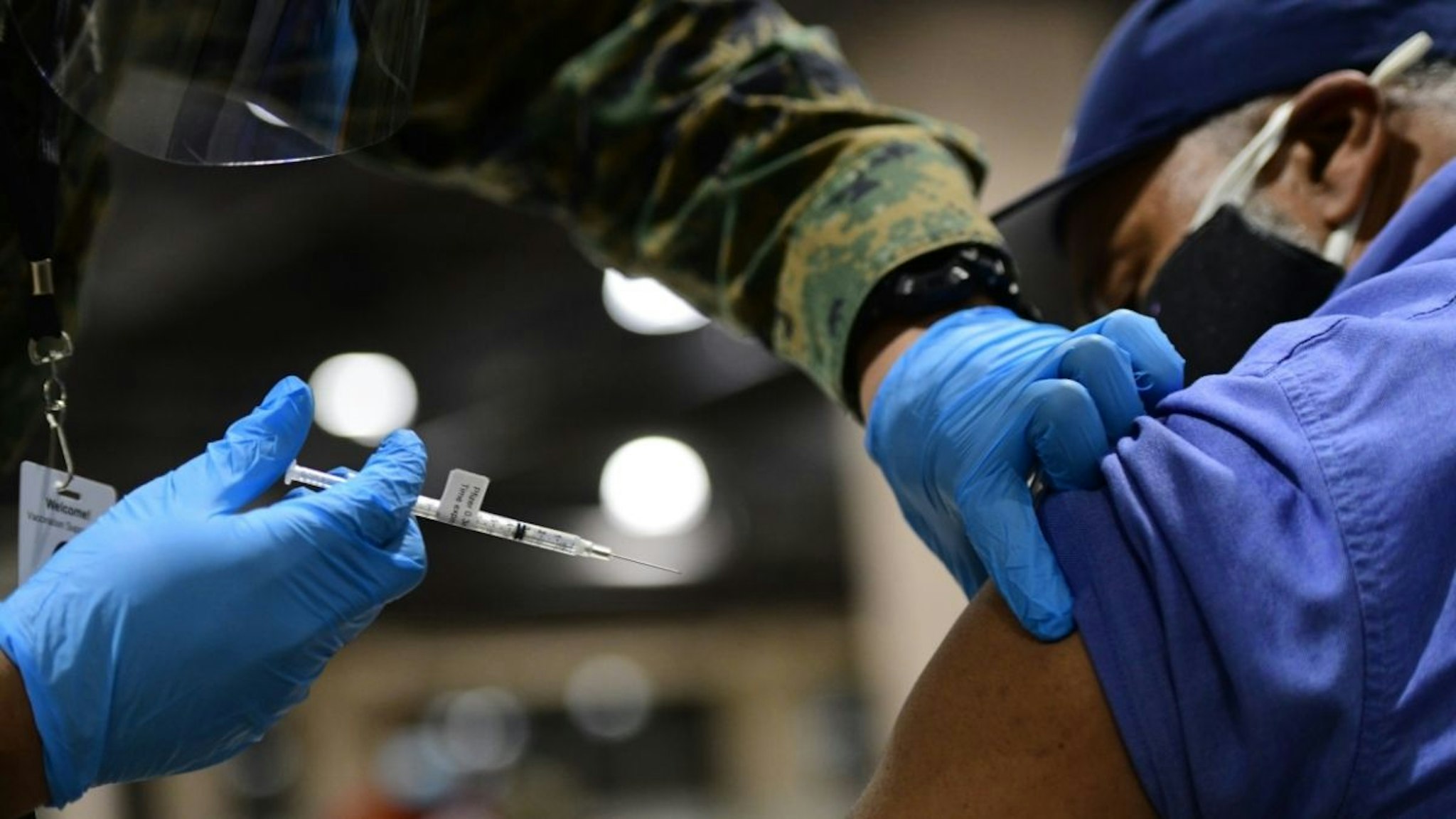 A member of the U.S. Armed Forces administers a dose of the Pfizer COVID-19 vaccine at a FEMA community vaccination center on March 2, 2021 in Philadelphia, Pennsylvania.