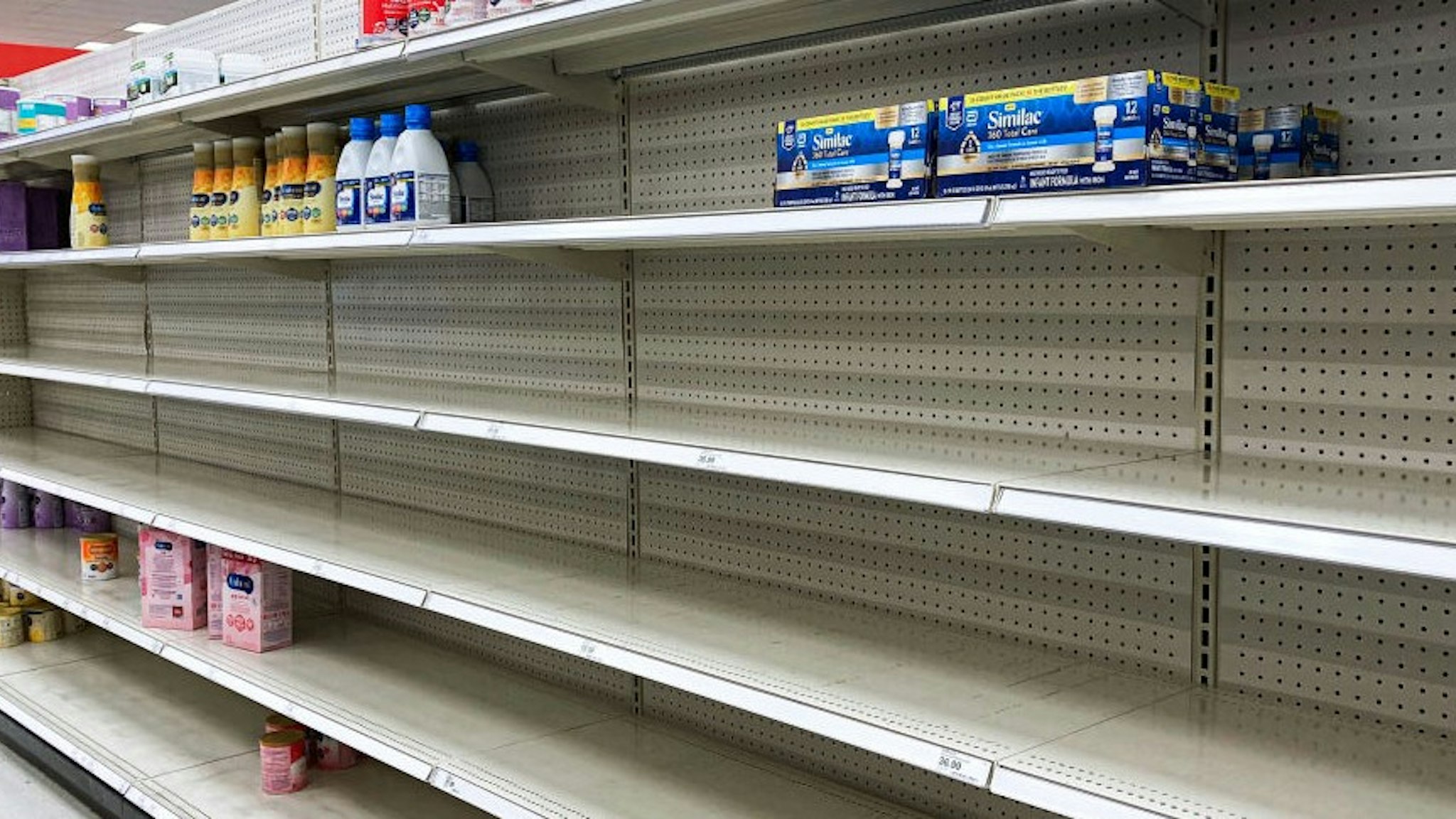 ORLANDO, FLORIDA, UNITED STATES - 2022/05/08: A nearly empty baby formula display shelf is seen at a Target store in Orlando. Stores across the United States have struggled to stock enough baby formula, causing some chains to limit customer purchases. While manufacturers report that they are producing at full capacity, it's still insufficient to meet the current demand, which has been aggravated by product recalls. (Photo by