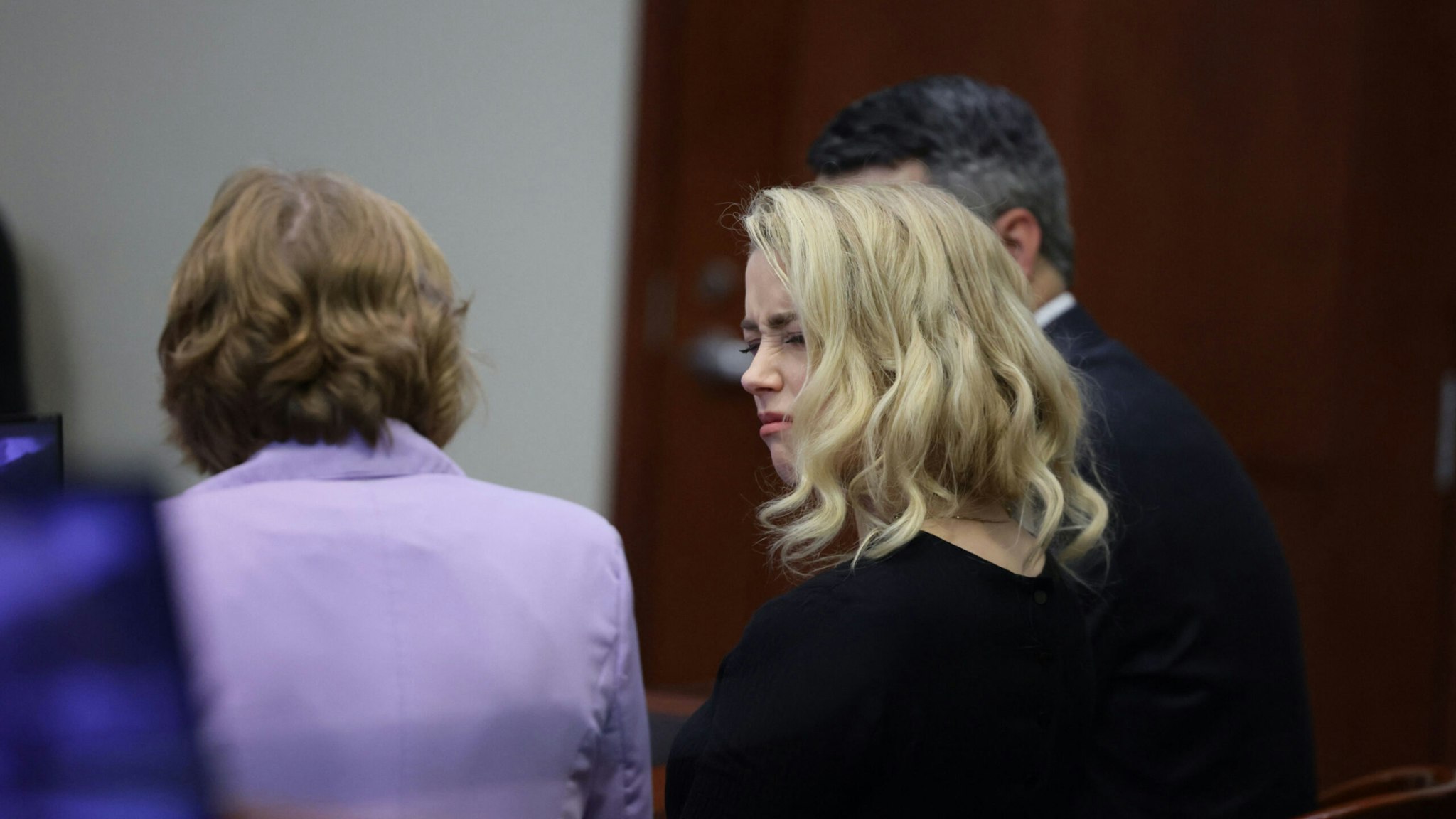 Actor Amber Heard looks at her lawyer before the jury said that they believe she defamed ex-husband Johnny Depp while announcing split verdicts in favor of both her ex-husband Johnny Depp and Heard on their claim and counter-claim in the Depp v. Heard civil defamation trial at the Fairfax County Circuit Courthouse in Fairfax, Virginia, on June 1, 2022.