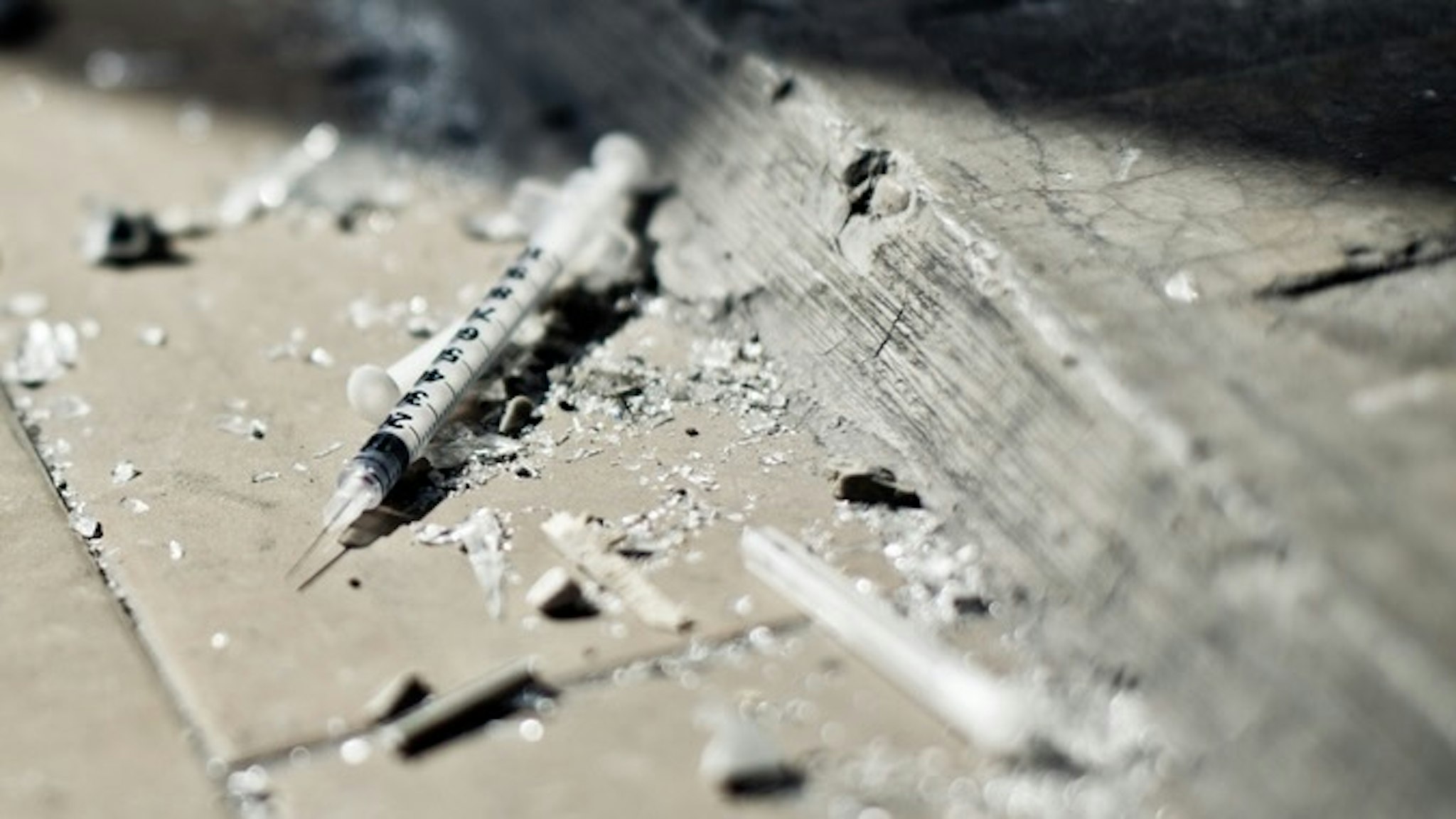 Drugs Addiction equipment - stock photo Injection on the floor - selective focus sanjeri via Getty Images
