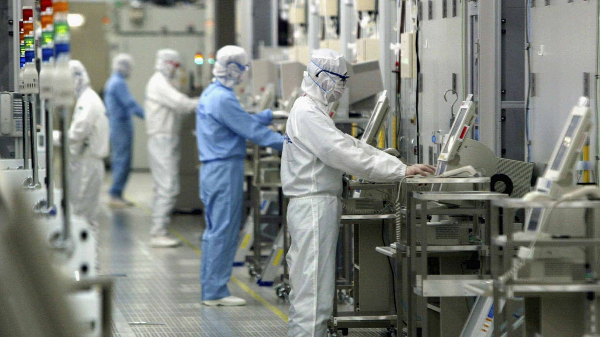 Technicians at work in the clean room of the Fab Equipment at a semiconductor company, Renesas Technology Corp. on June 17, 2004 in Ibaraki, Japan.
